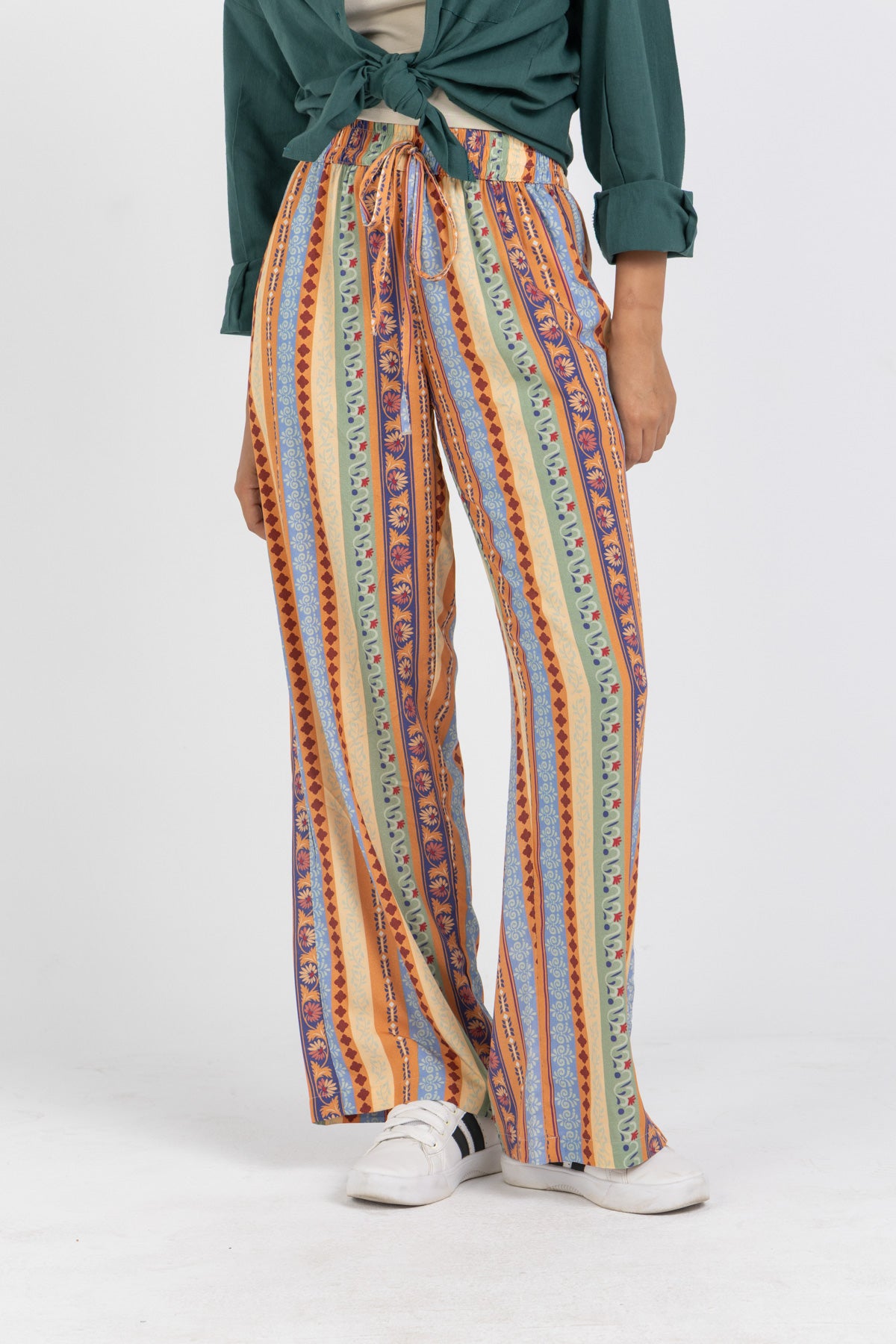 Person wearing colorful striped pants on a white background