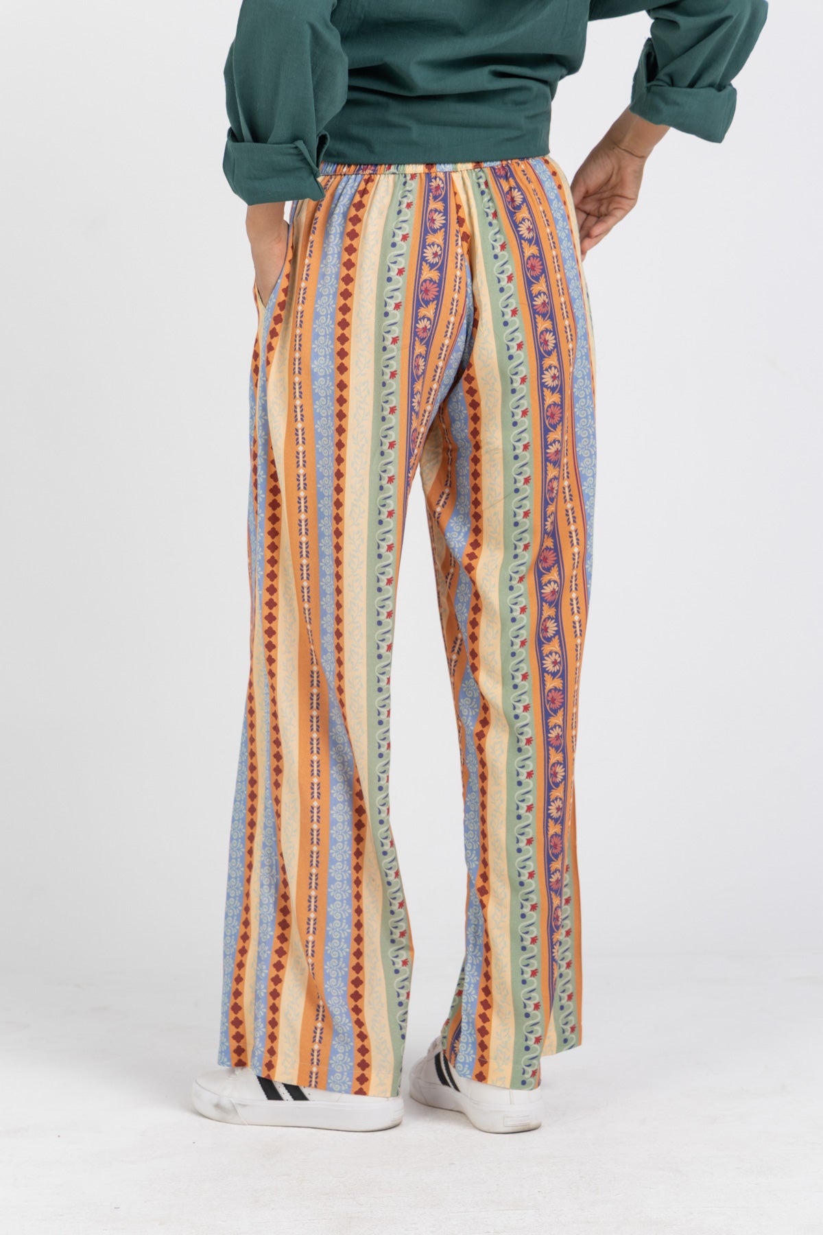 Person wearing colorful striped pants on a white background